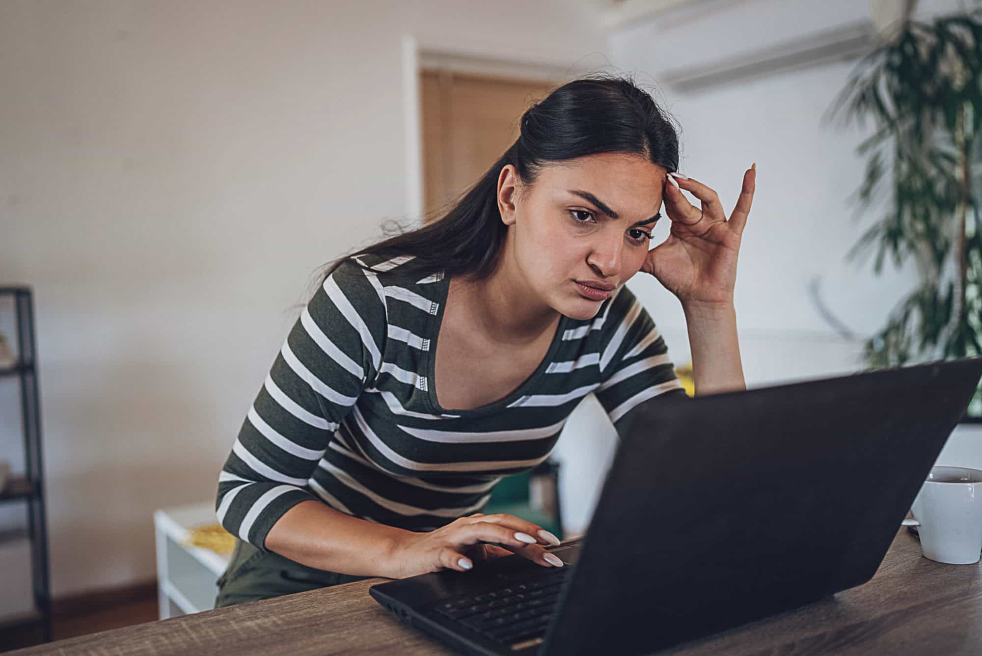 Young woman experiencing online fraud on computer