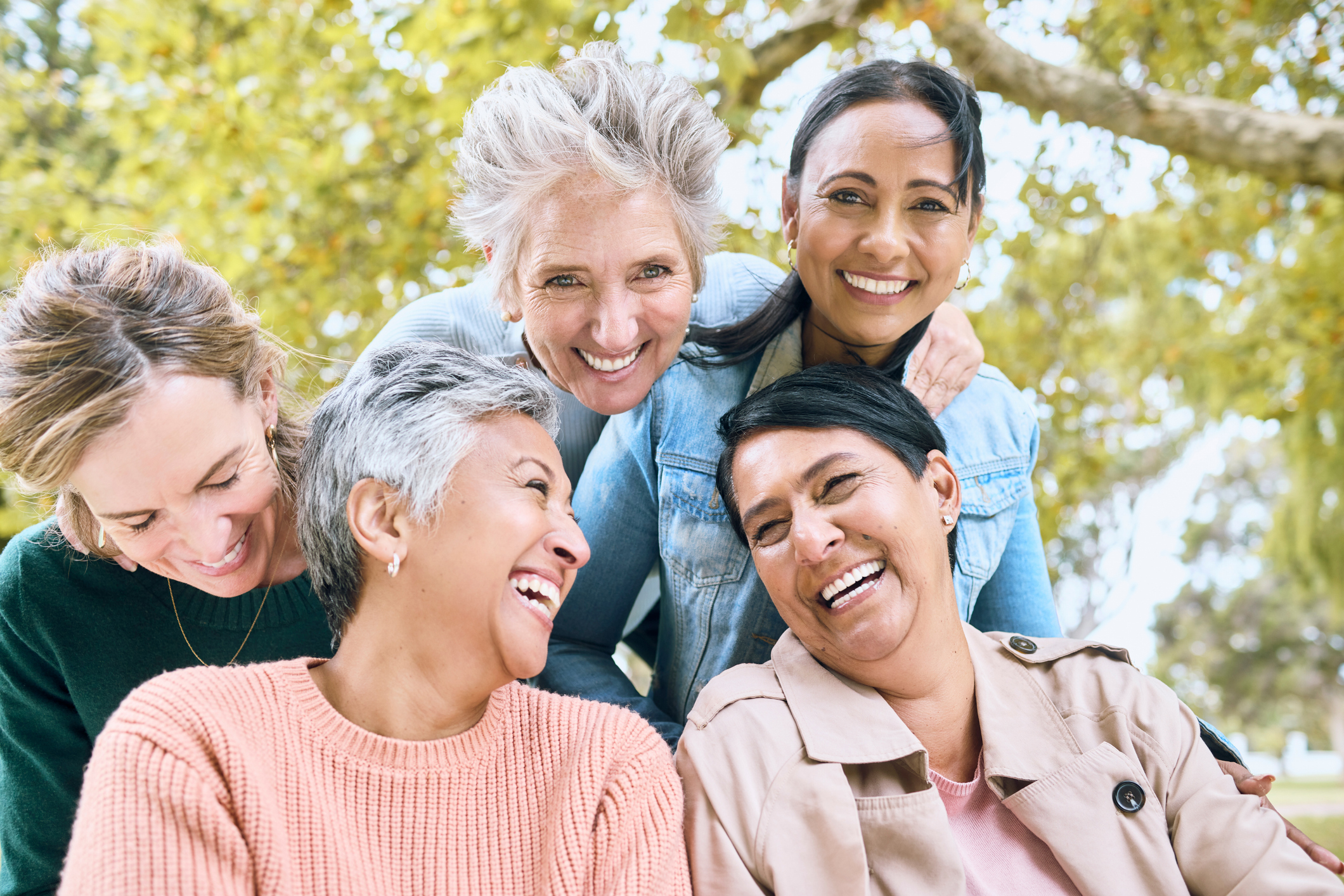 Senior women, laughing or bonding in nature park, public garden or relax environment in retirement, support or trust. Smile, happy or diversity elderly friends in comic joke, funny meme or emoji face